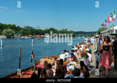 Henley-on-Thames, UK. 5th July, 2019. Henley Royal Regatta is the pre-eminent, river-based international rowing regatta. It has an unparalleled tradition and place in the hearts of top rowers around the world where 100,000 spectators are due to attend on semi-finals day Saturday 6 July 2019 . Visitors line the banks of the River Thames to picnic and enjoy the thrilling racing.  Credit Gary Blake/Alamy Live News Stock Photo