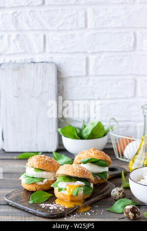 Veggie burger with poached egg and sorrel in a curd bun on rice flour as a healthy breakfast concept in the style of a life stile. Stock Photo