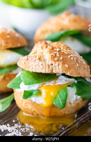 Veggie burger with poached egg and sorrel in a curd bun on rice flour as a healthy breakfast concept in the style of a life stile. Stock Photo