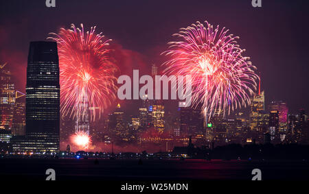Fireworks are being set off from barges on the river between Jersey City and New York. Stock Photo