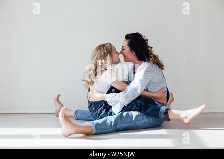 Mom and daughter play cuddles at home on the floor Stock Photo
