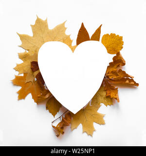 Yellow autumnal leaves flat lay, heart shaped copy space. Various yellow leaves isolated on white background, creative seasonal layout, autumn concept Stock Photo
