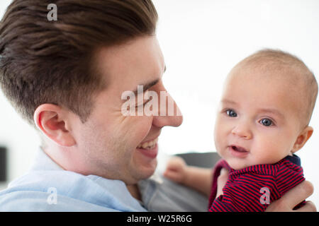 Loving Father Cuddling Cute Baby Son At Home Stock Photo