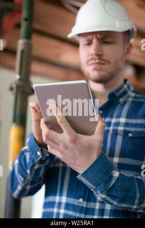 Architect Inside House Being Renovated Using Digital Tablet Stock Photo