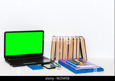 School stationery accessories - notebook, copybook, green screen laptop, plastic folder, pens, glasses, paper clips, stickers, notepads, smartphone, s Stock Photo