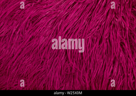 A close up of dark pink shaggy,faux fur fabric.