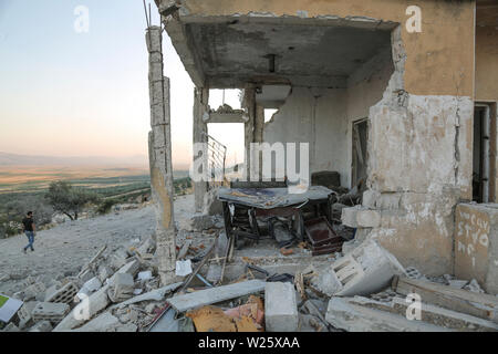 Muhambal, Syria. 06th July, 2019. A man walks past a building that was destroyed in an airstrike, allegedly carried out the day before by the Syrian government on the town of Muhambal in the rebel-held Idlib Province. Credit: Anas Alkharboutli/dpa/Alamy Live News Stock Photo