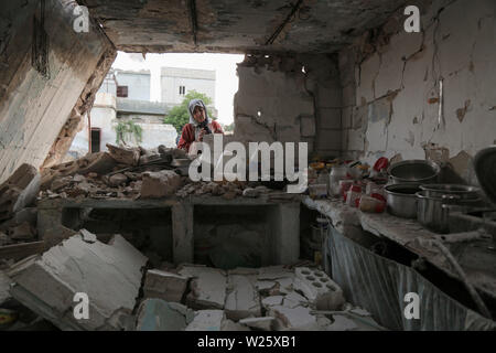 Muhambal, Syria. 06th July, 2019. A woman inspects the rubble of a building that was destroyed in an airstrike, allegedly carried out the day before by the Syrian government on the town of Muhambal in the rebel-held Idlib Province. Credit: Anas Alkharboutli/dpa/Alamy Live News Stock Photo