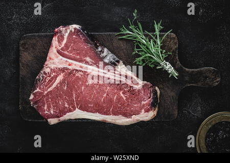 Prime Dry Aged Beef Raw T-bone Steak on Vintage Cutting Board Stock Photo