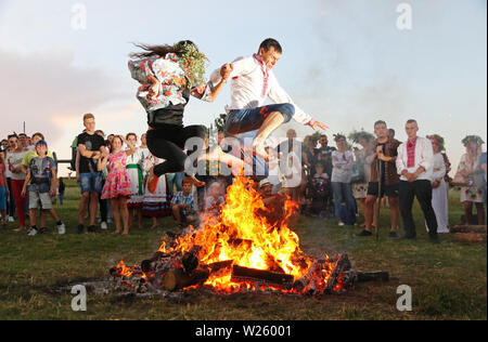 Kyiv, Ukraine - July 6, 2018: Young people jump over the flames of bonfire during the traditional Slavic celebration of Ivana Kupala holiday in Pirogo Stock Photo