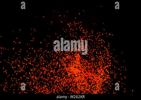 Orange dust particles explosioon on black background. Stock Photo