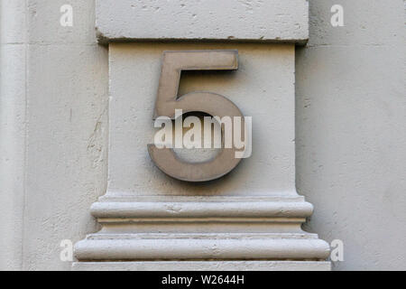 House number 5 with the five in silver brushed metal on a pillar Stock Photo