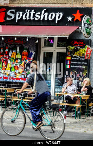 People drinking outside Late-night shop, Spatshop Spati Spatkauf in Berlin Friedrichshain city street, Germany Stock Photo