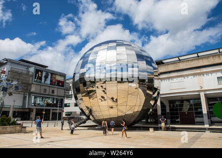 Bristol, UK - June 30th 2019: A view of Millennium Square in the city of Bristol in the UK.  The large reflective silver sphere is home to a Planetari Stock Photo