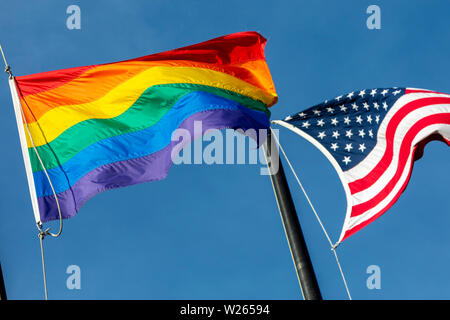 A rainbow and American flag flying together in Boston, Massachusetts, USA