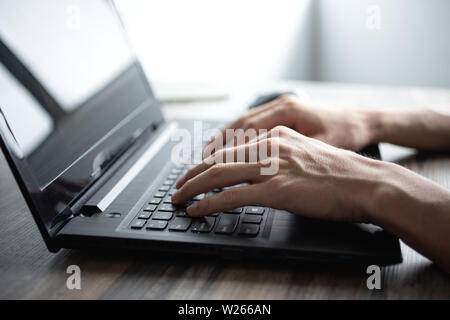 Manila, Philippines - June, 29, 2019: Male hands typing on black laptop computer keyboard Stock Photo