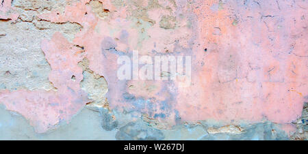 Old weathered painted wall background texture. Light grey blue pink dirty peeled plaster wall with falling off flakes of paint Stock Photo