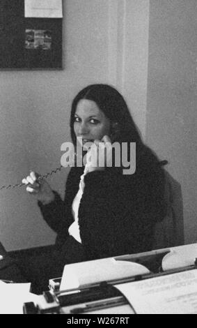 1970s, historical, female office worker at her desk speaking on the telephone beside a typewriter, England, UK. Stock Photo