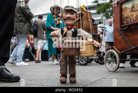 Berlin, Germany. 06th July, 2019. A barrel organ player from the Czech Republic shows a marionette with barrel organ at the 40th International Festival of Barrel Organ at Breitscheidplatz. Until 07.07.2019, the typical sounds from the barrel organ will be heard around Breitscheidplatz at a small folk festival with market stalls. Credit: Paul Zinken/dpa/Alamy Live News Stock Photo