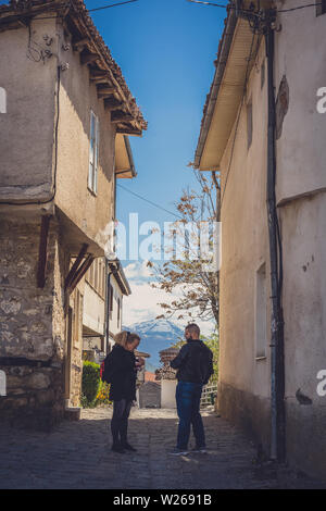 Ohrid, Northern Macedonia -  April 2019 : Man selling eggs to a local woman on a narrow street in Ohrid town Stock Photo