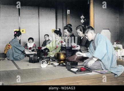 [ 1900s Japan - Japanese New Year - First Meal ] —   The first meal of the year, includes a soup called zoni, which features mochi.  This image is part of The New Year in Japan, a book published by Kobe-based photographer Kozaburo Tamamura in 1906 (Meiji 39).  20th century vintage collotype print. Stock Photo