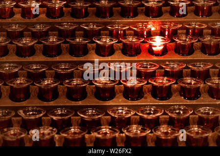 Many candle flames glowing in the dark.Candles in the church. Stock Photo