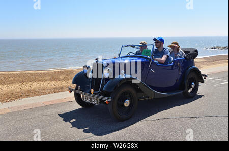 Classic Blue Car being driven along seafront promenade. Stock Photo