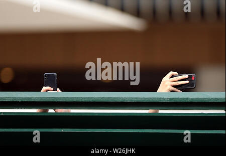 A general view of spectators filming the match on their mobile phones on day six of the Wimbledon Championships at the All England Lawn Tennis and Croquet Club, Wimbledon. Stock Photo