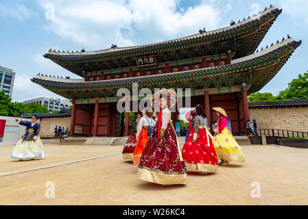 SEOUL, SOUTH KOREA - JUNE 1, 2019: A group of women in traditional korean costume are about to enter the Changdeokgung Palace through the main gate Stock Photo