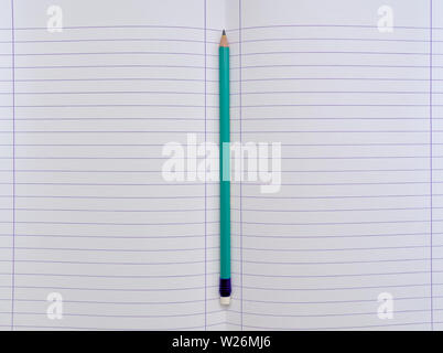 Isolated open blank  notebook with lined papers and green pencil. Stock Photo
