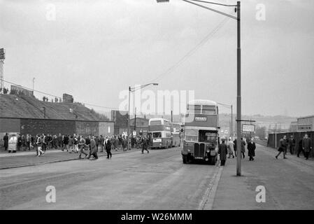 Match Day at Leeds United Football Ground. Probably taken during the 1960s, the image shows the home side fans getting of the busses to see their team in action. The main bus in the image is a Waymann Bodied AEC Regent III that would have been new in 1952 Stock Photo