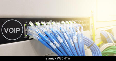 Network Line Cables in data center room background with virtual reality icon diagram,Row of blue UTP network cables that are connected to a switch Stock Photo