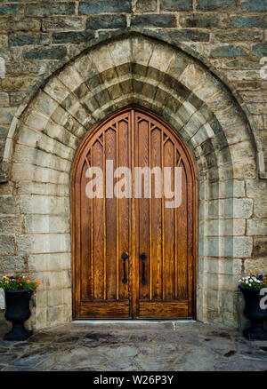 A large wooden oak arched doorway on St. Peter's Roman Catholic Church, Brownsville, Pennsylvania, USA Stock Photo