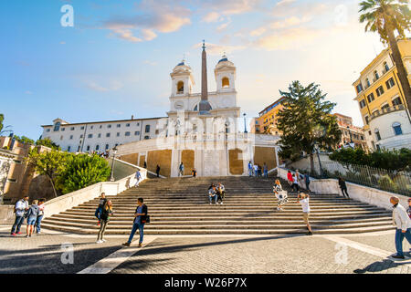 Tourists walk up the Spanish Steps towards the Trinita dei Monti church on a sunny day in Rome, Italy Stock Photo