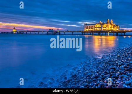 The sea pier of Sellin at night with pebbles in the foreground Stock Photo