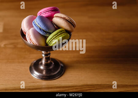 macaroons in a metal bowl on a wooden table Stock Photo