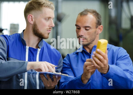 technicians measure contract resistance in control panel Stock Photo