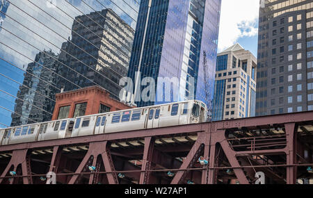 Chicago cityscape, spring day. Chicago train on a steel bridge, downtown on high rise buildings background, low angle view Stock Photo