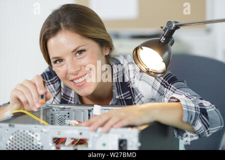 happy female technician plug in cpu microprocessor to motherboard socket Stock Photo