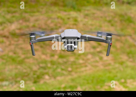 View of modern consumer drone with camera on gimbal in hover mode outdoors Stock Photo