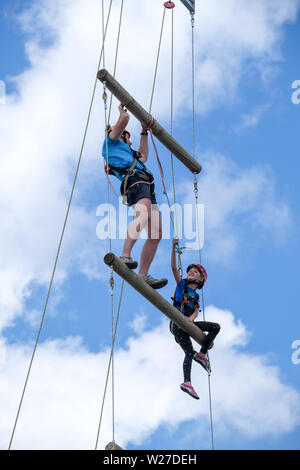 Dortmund/Germany, 19th June 2019. At the Protestant Church Congress 2019 in Dortmund, a girl (10 years) climbs up to a height of 17 meters on a ladder to heaven. A helper assists with ropes to reach the next level. Stock Photo