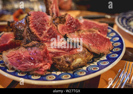 A cut Florentine Steak (Bistecca alla Fiorentina), a porterhouse steak done Florentine style. Landscape format. Stock Photo