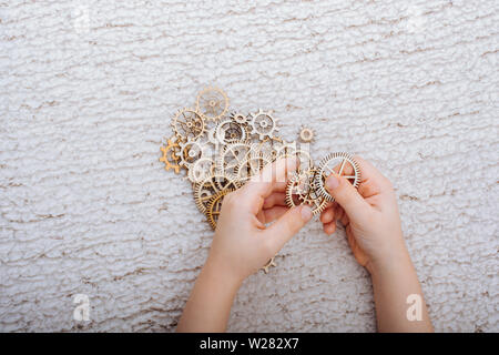 Hand holding gear wheels as the concept of mechanism Stock Photo