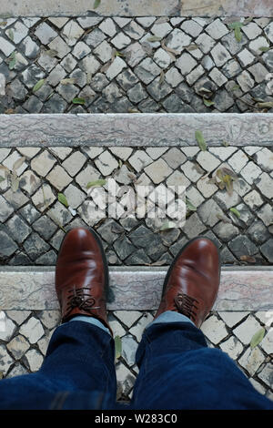 Brown shoes on the stone pavement. View from above