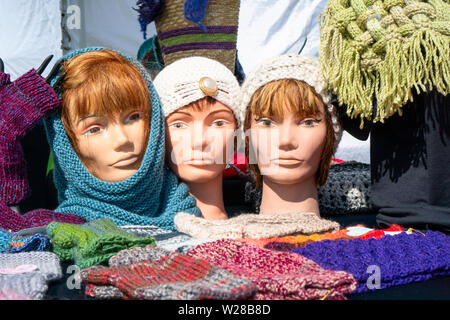 Knitted hats, scarves  and mittens, with three mannequin heads on display Stock Photo