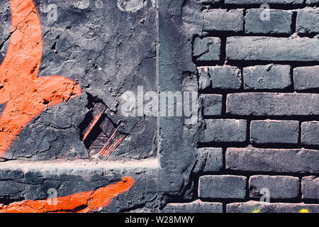 Grunge, gray dark, rough background with orange paint. Brick wall on the street Stock Photo