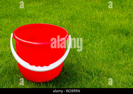 Colored plastic garden buckets on background of green grass Stock Photo
