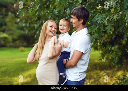 Happy family together in the summer park. Mother, father and child son in nature. Stock Photo