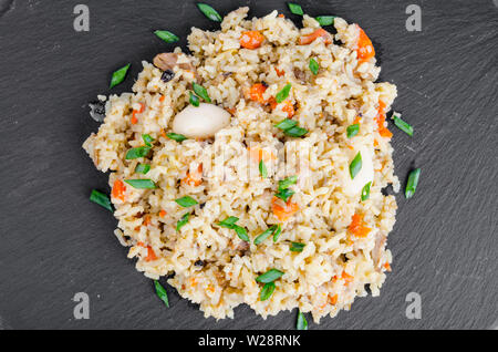 Bunch delicious golden pilaf on black stone Stock Photo