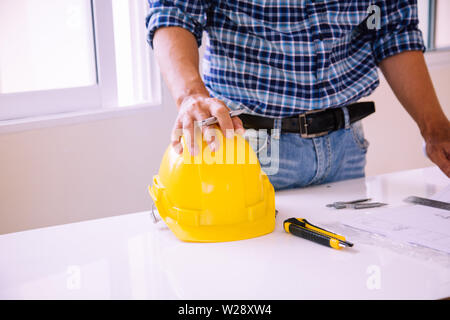 architect man reading with blueprint to build houses. After agreeing the employment price the cost of construction and repair real estate Stock Photo